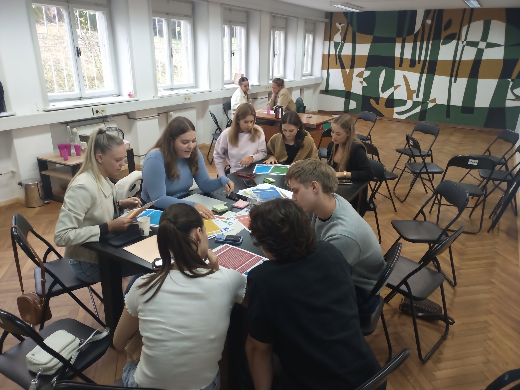 Young people working in groups with colourful SDGs Intelligence Cards during a workshop in Maribor